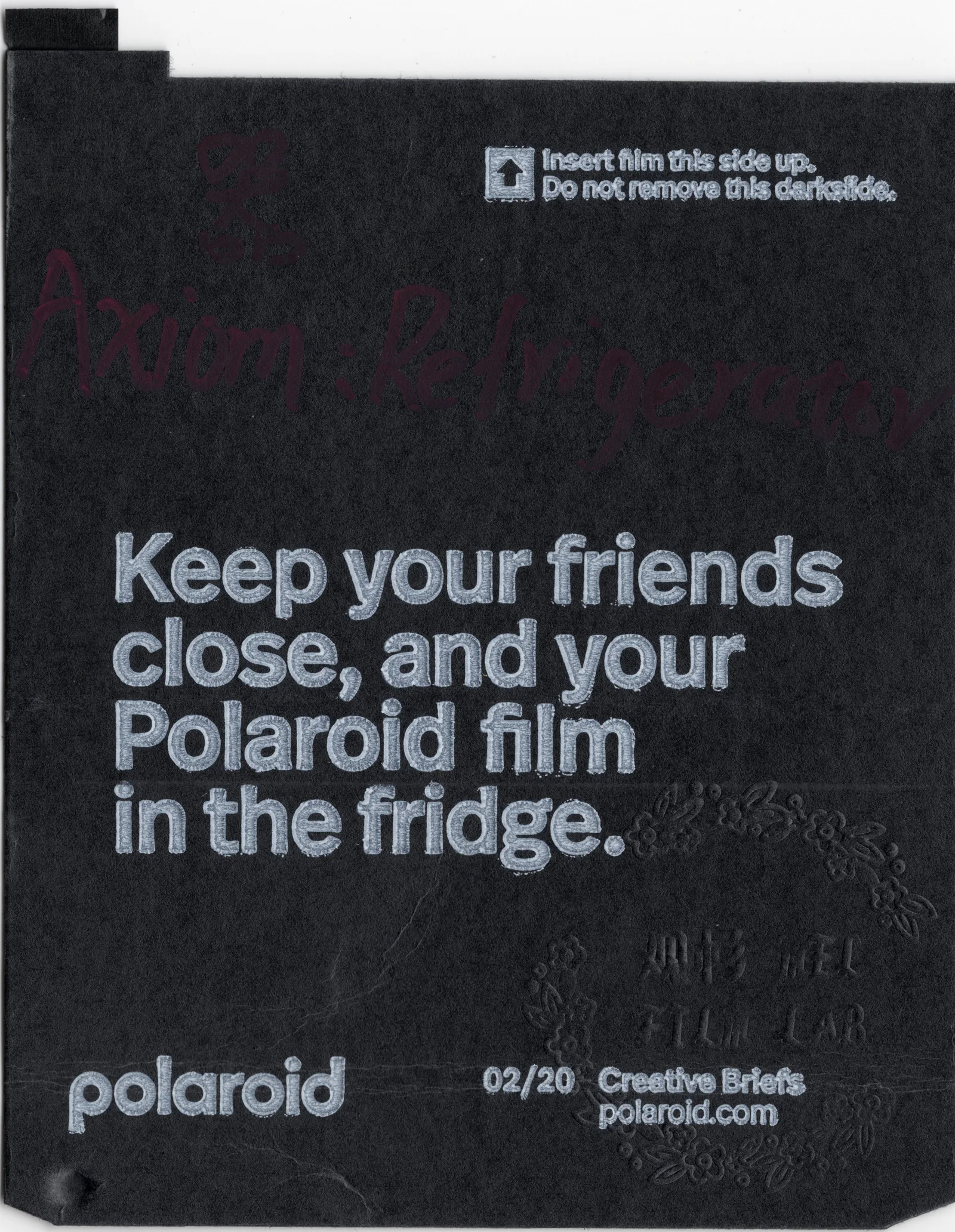 Black Polaroid darkslide with text about keeping film in the fridge.