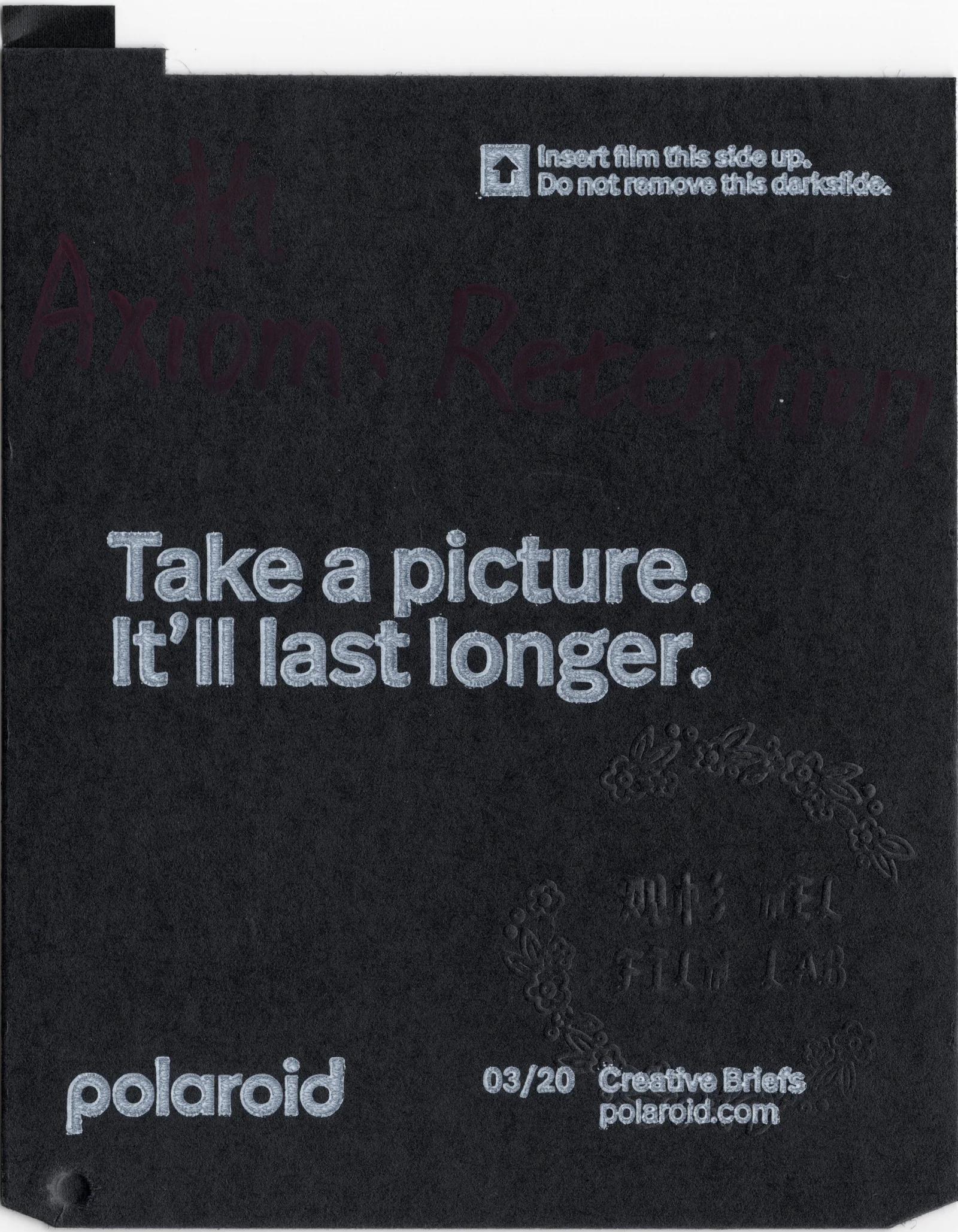 Black Polaroid darkslide with text about taking a picture and handwritten title marks.