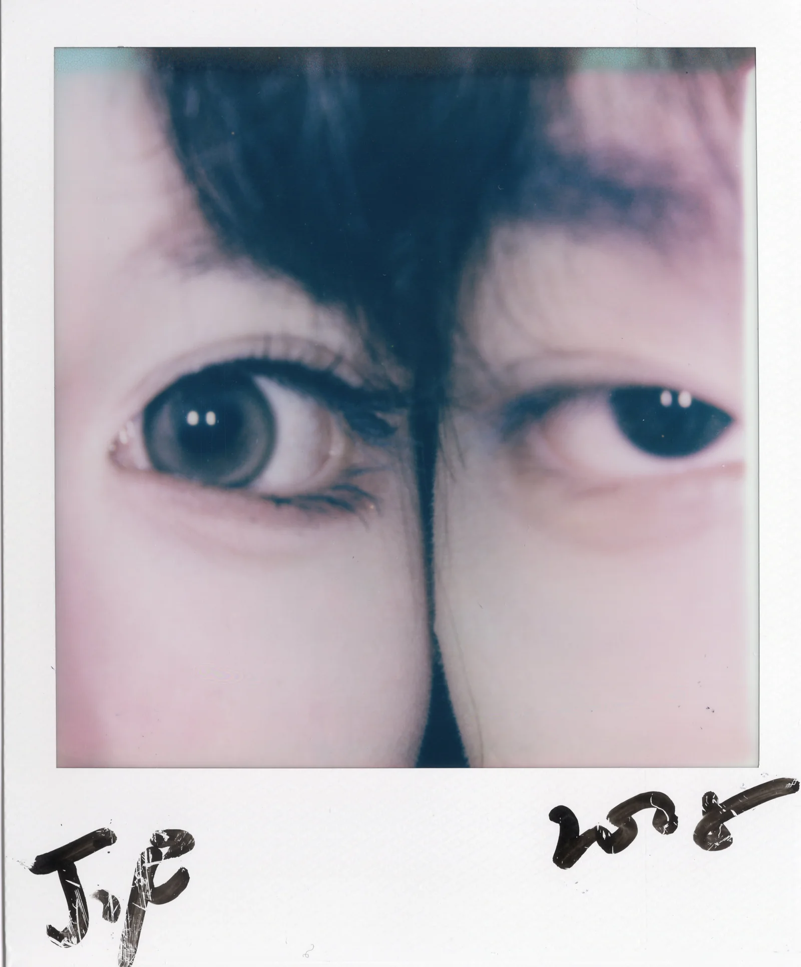 Close Polaroid artwork of two eyes divided by a dark vertical mark.