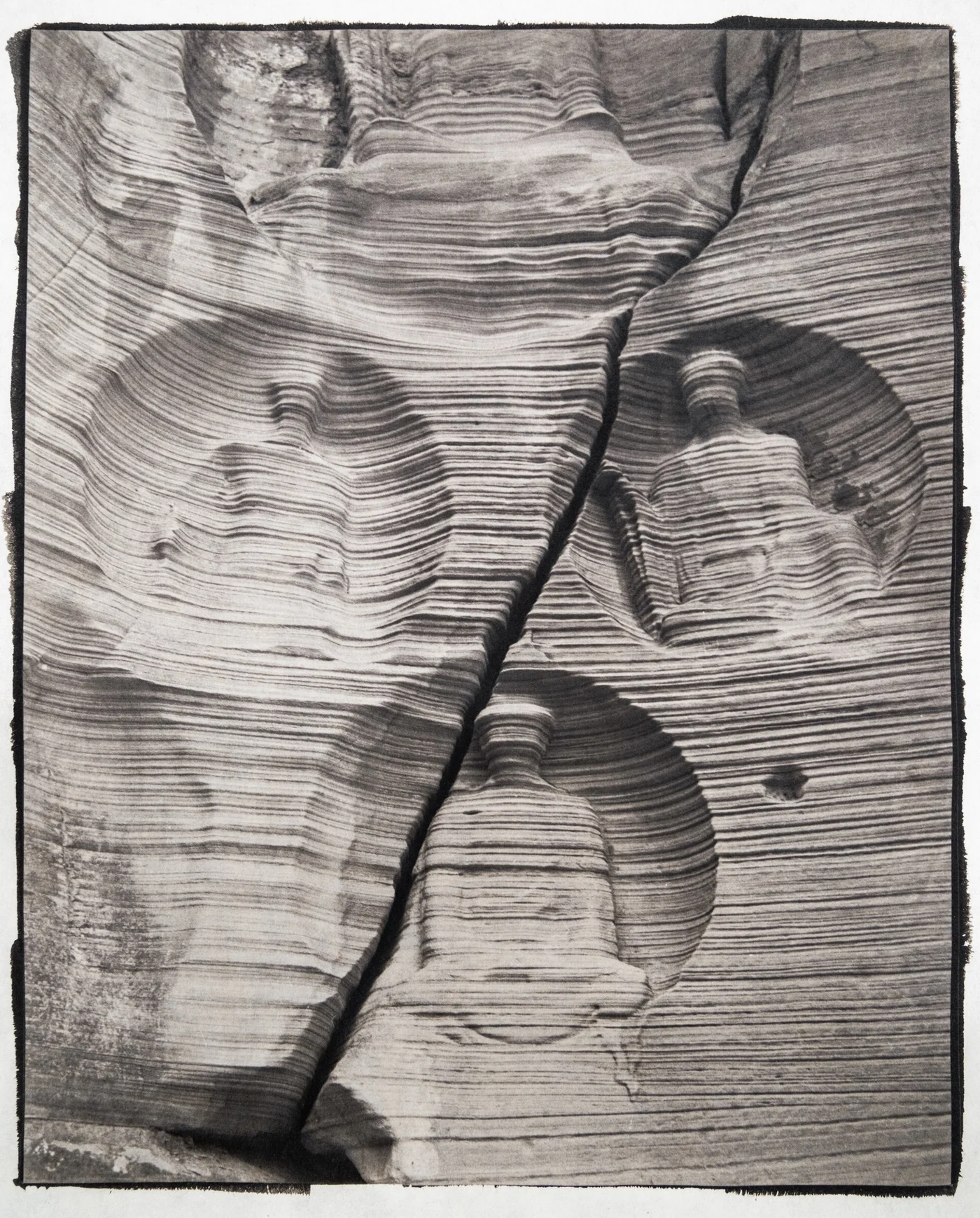 Black and white handmade paper fibre study with circular tonal impressions.