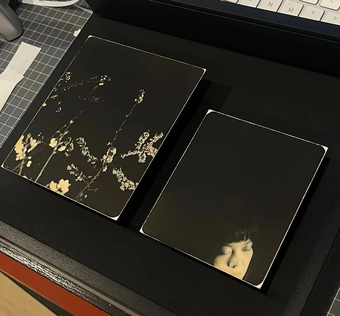 Boxed presentation study with dark framed print surfaces and a small image detail.